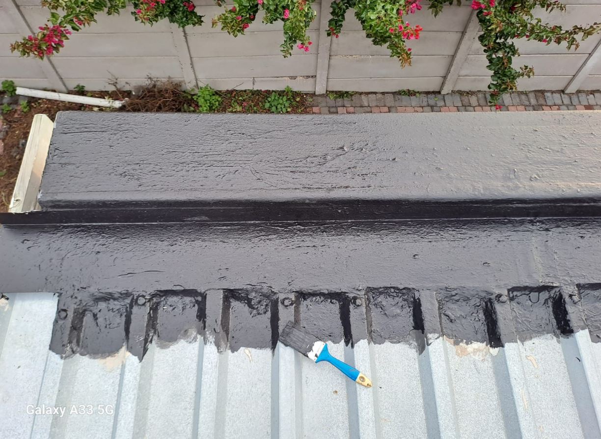 Silkhan liquid rubber sealing a parapet wall to corrugated metal roof joint